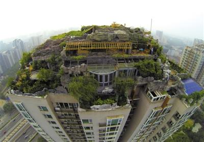 　　昨日，身穿橘黃色馬甲的工作人員在人濟(jì)山莊樓頂拆除違章建筑。新京報記者 吳江 攝