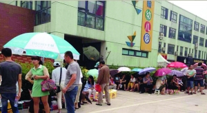 金壇市實(shí)驗(yàn)幼兒園門前，家長(zhǎng)在排隊(duì)