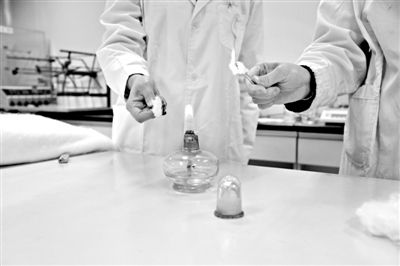 實(shí)驗(yàn)人員操作的燃燒檢測法中，真蠶絲離開火焰就熄滅(左)。