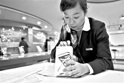 11月6日，北京移動(dòng)西直門營(yíng)業(yè)廳的工作人員在為顧客購(gòu)買的4G手機(jī)登記。新華社發(fā)