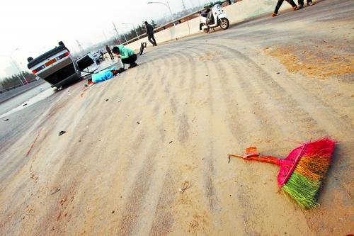 被撞的環(huán)衛(wèi)工躺在地上，身上蓋著藍(lán)色布?jí)K，現(xiàn)場(chǎng)除散落的汽車碎片外，還留有被撞斷的掃帚。