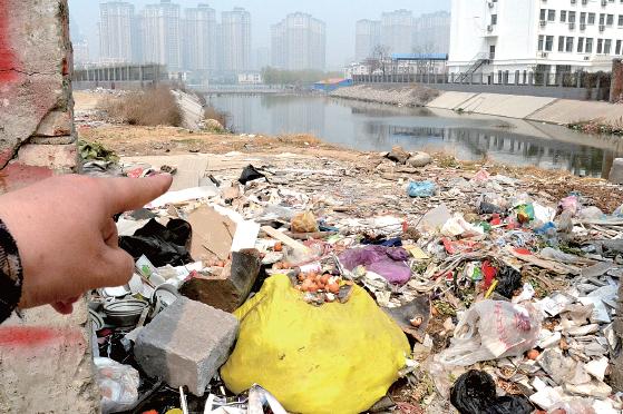 金水河長(zhǎng)江路橋下河水發(fā)臭，水邊堆放眾多垃圾