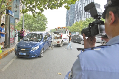 在金水路，交警對在機動車道違法停放的車輛施行拖離