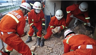 消防人員在清理熔鹽爐倒塌的廢墟。