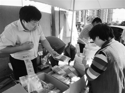 昨日，河南企業(yè)家劉春喜在京“練攤”，為顧客挑選綠豆。新京報記者 張玉學 攝