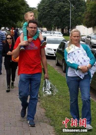 圖為一個(gè)白人家庭，由父母帶著孩子到曼德拉家門外悼念。中新社發(fā) 宋方燦 攝