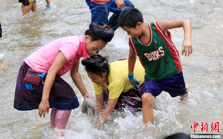 7月9日，村民在小河里摸魚(yú)搶魚(yú)。譚凱興 攝