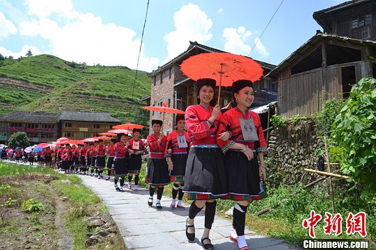 圖為新娘身著瑤族盛裝在伴娘和親友的陪伴下“出嫁”。中新社發(fā) 韋吉陽 攝