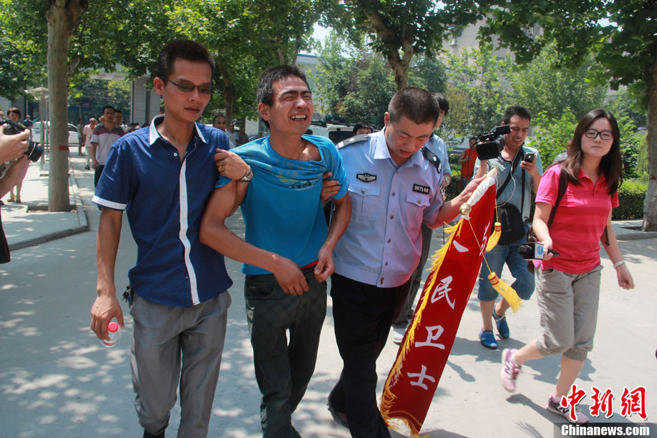 圖為獲救嬰兒父親情緒一度失控，當(dāng)?shù)鼐焦ぷ魅藛T對(duì)其進(jìn)行攙扶。張一辰 攝