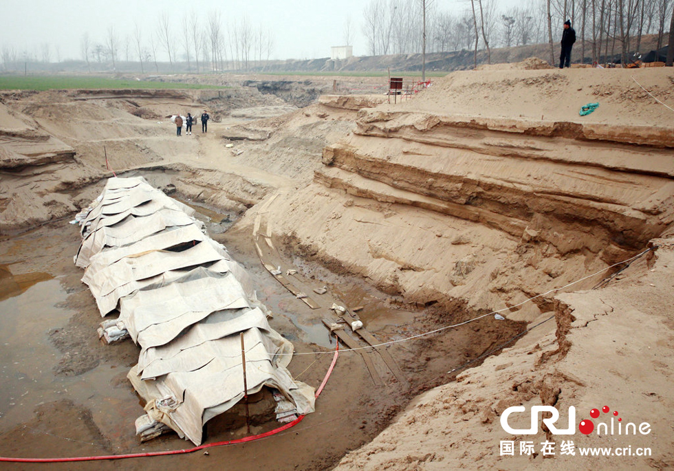 2014年1月6日，河南洛陽古沉船發(fā)掘現(xiàn)場，近日有雨雪天，考古人員給古沉船披上一層“雨衣”。