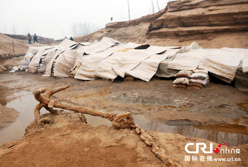 2014年1月6日，河南洛陽古沉船發(fā)掘現(xiàn)場，古沉船鐵錨從見天日，靜靜地躺在古船旁。
