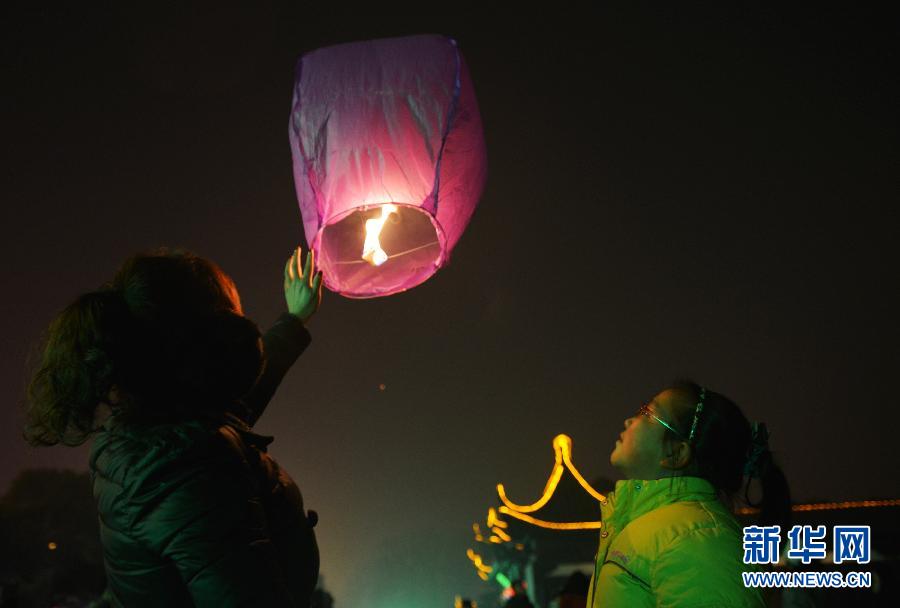 　1月30日，游客在江蘇省鎮(zhèn)江市金山公園門口放飛孔明燈。
