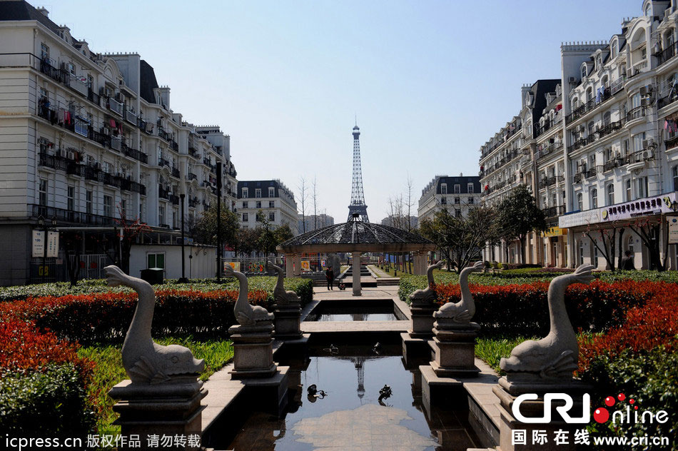 　2014年3月21日，杭州天都城，農(nóng)民在山寨埃菲爾鐵塔下耕作。圖片來源：東方IC