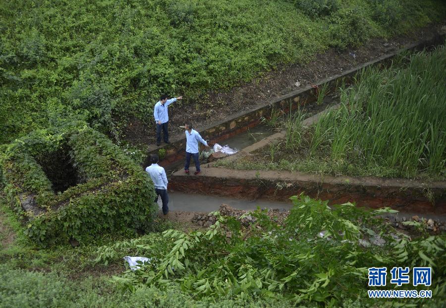 5月18日，工作人員在槽罐車泄漏現(xiàn)場(chǎng)附近的水渠邊查看情況。