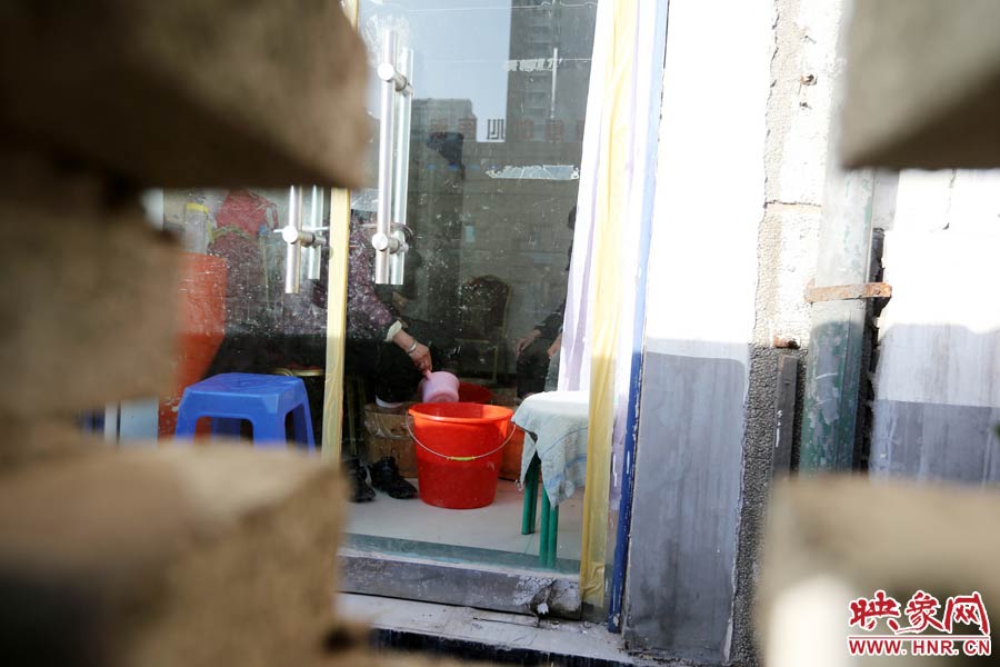 墻內(nèi)一家店面正常營(yíng)業(yè)。