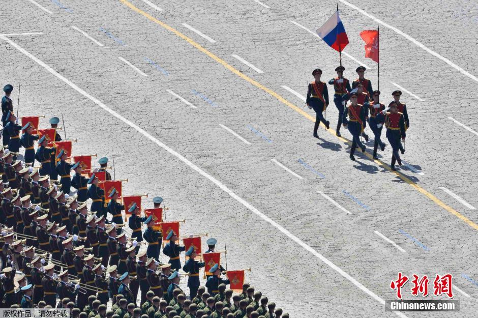 圖為俄羅斯國(guó)旗從受閱部隊(duì)前經(jīng)過(guò)。