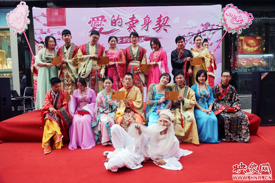 現(xiàn)場(chǎng)8對(duì)兒年輕男女舉起“賣(mài)身契”集體拍照。