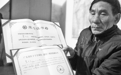 裴富才老人拿著有關(guān)部門頒發(fā)的證書(shū)