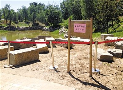 圓明園規(guī)月橋橋體構(gòu)件區(qū)域的警戒線和提示牌。 新京報記者 鄧琦 攝