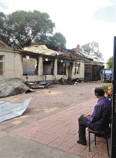 7月27日，海倫聯(lián)合敬老院內(nèi)，幾名老人看著對面被燒毀的特護(hù)病房。新京報(bào)記者 涂重航 攝