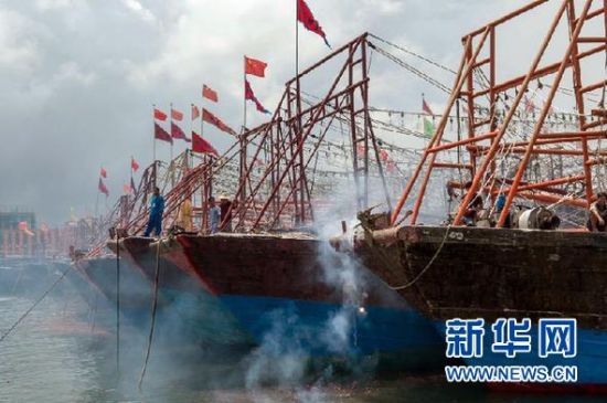 2013年8月1日 南海開漁日 臨高迎新港 8月1日，海南省臨高縣漁民在船上鳴放鞭炮慶祝武蓮港開港。