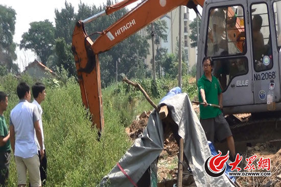 陳寶成手持自制刀斧守在挖掘機(jī)旁阻止便衣民警靠前。駕駛室內(nèi)，張朋珂正向受害人郭曉剛身上澆汽油。（視頻截圖）