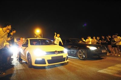 8月24日晚，東壩中街飆車現(xiàn)場，兩輛車并排等待出發(fā)指令，旁邊許多愛好者前來觀看比賽。新京報(bào)記者