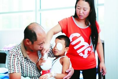 斌斌手術后第一天恢復良好，斌斌父母在用玩具逗他開心供圖/嚴益