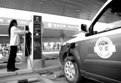 9月11日，懷柔區(qū)，電動(dòng)出租車司機(jī)正在為車輛充電。