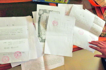 60歲的市民仇先生為了辦理公證所需的這些證明材料,半個月時間里跑了30多趟腿。記者　李萌博　攝