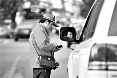 10月15日，朝陽區(qū)東大橋路，停車管理員從腰間掏出一個(gè)專用POS機(jī)，正在錄入停車信息。新京報(bào)記者 周崗峰 攝