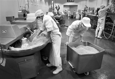 昨日，位于順義李遂開發(fā)區(qū)的慶豐包子鋪配送中心生產(chǎn)車間，工人們正在斬拌胡蘿卜餡料。