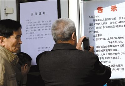 昨日，家長(zhǎng)在西安市楓韻幼兒園查看有關(guān)兒童體檢的告示。