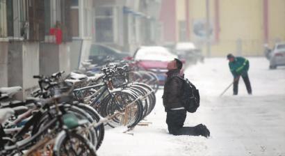 小伙子跪在樓前，一直抬頭看著樓上。 孫立國/攝