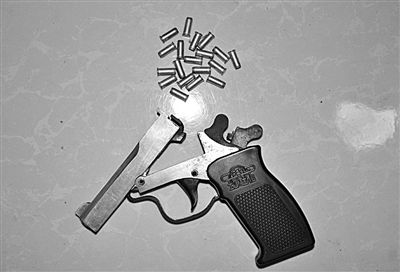 警方從搶劫嫌疑人處起獲的贓款和發(fā)令槍、子彈。警方供圖