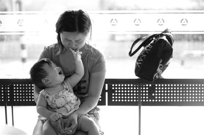 昨日，肯德基京廣中心店門口，姜女士提起跟養(yǎng)父母關(guān)系時落淚，懷中女兒笑著跟她玩。