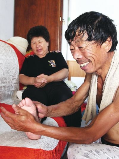 慈成富為老伴按摩。