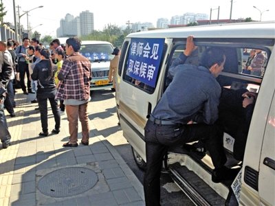 昨日，朝陽區(qū)看守所門前有人排隊(duì)。大門外還停有多輛寫有“律師會(huì)見”字樣的車。