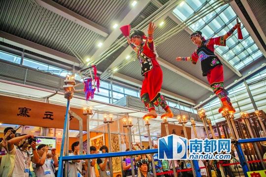 2號(hào)展館，苗族姑娘表演踩燈泡絕技《電光玫瑰》，赤腳踩上40瓦的燈泡并做出高難度動(dòng)作。 南都記者 霍健斌 攝