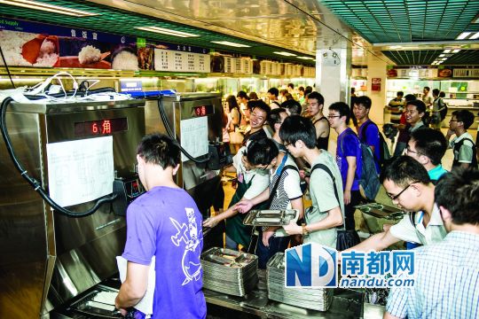 昨日，華南理工大學(xué)一食堂內(nèi)，學(xué)生們正在使用新安裝的自動打飯機打飯。中新社發(fā)