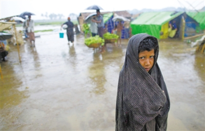 5月14日，緬甸若開邦實(shí)兌難民營，羅興亞族難民在雨中行走。熱帶風(fēng)暴“馬哈森”即將登陸緬甸，這里的難民開始乘船撤離。