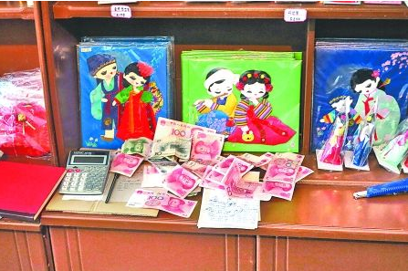 　　2012年6月21日，在朝鮮羅先特別市的一家商店里，柜臺上散落著一些人民幣。在朝鮮，人民幣比本國