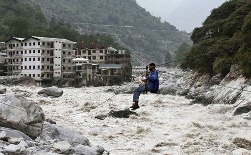 一名印度男子靠繩索渡河。