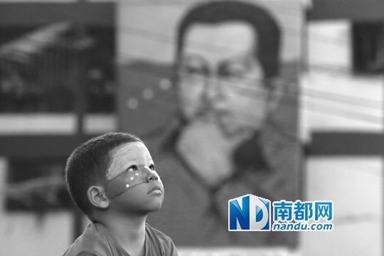 3月5日，一名委內(nèi)瑞拉兒童仰望天空，他身后是查韋斯的陵墓。
