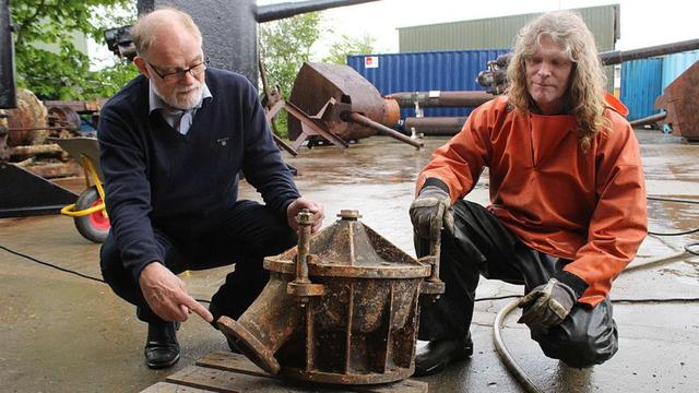 丹麥潛水員安德森（左）展示其打撈上來的U-78潛艇殘骸。