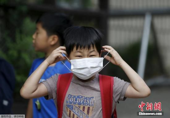 圖為當(dāng)?shù)貢r(shí)間2015年6月8日，韓國(guó)未停課的學(xué)校，學(xué)生課前戴口罩測(cè)體溫。