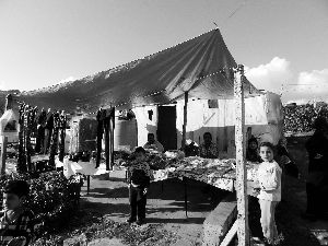 黎巴嫩一敘利亞難民營(yíng)，難民支起攤鋪賣衣服掙錢。