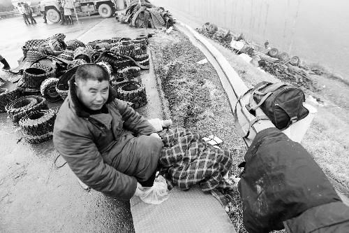 　出事司機(jī)的鞋找不到了，只好用塑料袋套著腳取暖