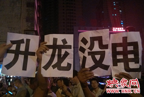  晚19點20分，業(yè)主舉著寫有“升龍沒電”的紙張