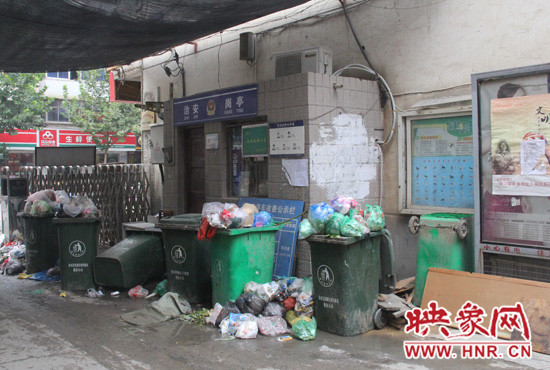 七個(gè)裝滿垃圾的大桶已經(jīng)將進(jìn)出小區(qū)的路堵了一半